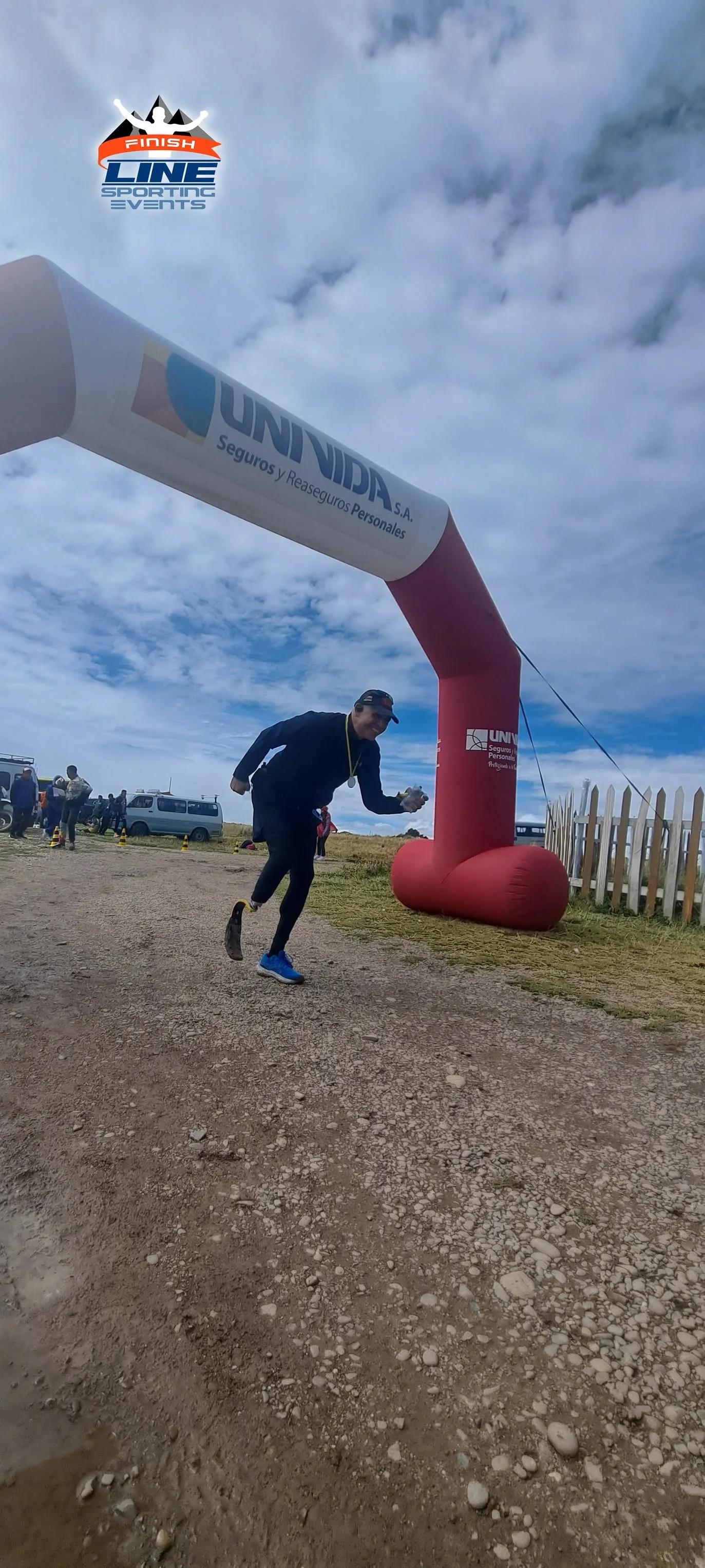 Corredor cruzando la meta del Maratón del Titicaca bajo el arco de llegada, en el altiplano.